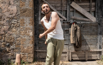 Davanti a una casa rurale, un uomo comune in movimento